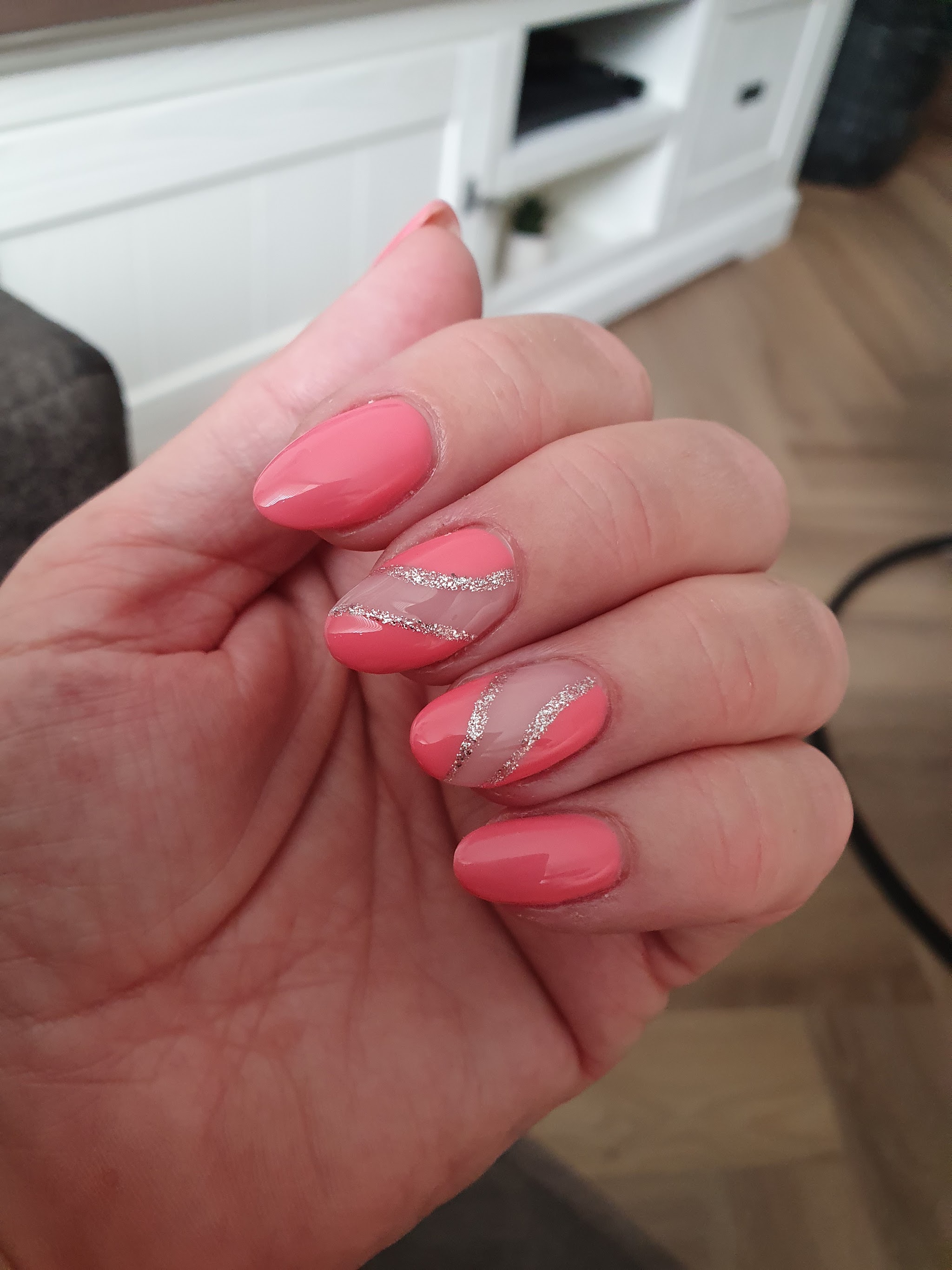 Koraalkleurige nagels met een zilveren glitterswirl
